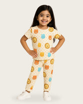 Child wearing a pajama set with animal prints on a plain background
